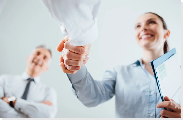 Two people shaking hands in a room.