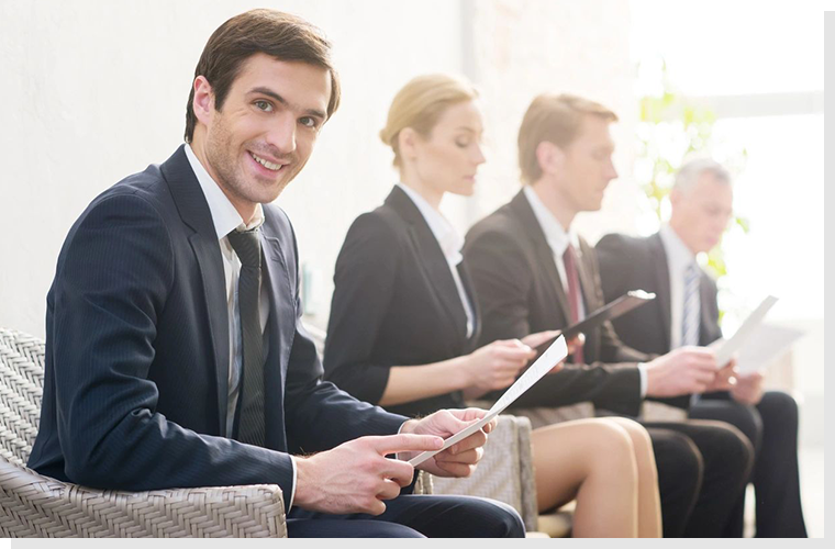 A group of people sitting in a row holding ipads.