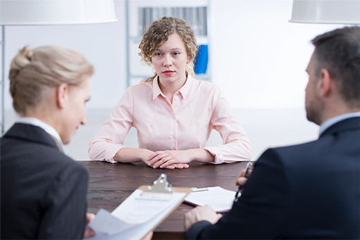 A woman sitting at a table with two other people.